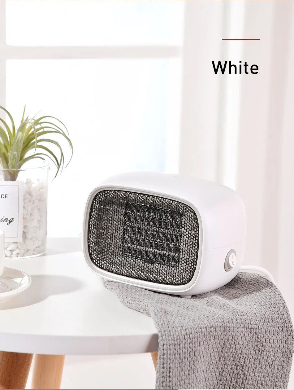 Compact green portable ceramic fan heater on a wooden desk