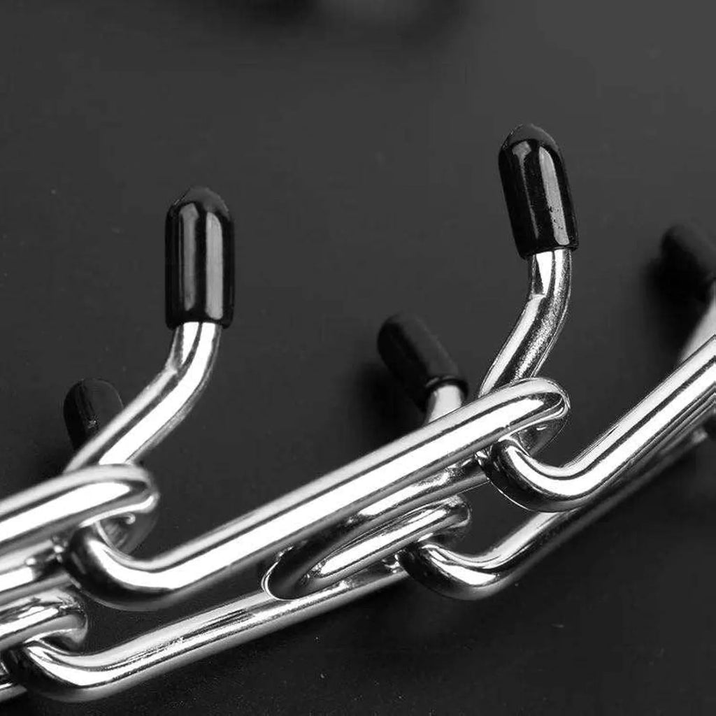 Stainless steel dog prong training collar with rubber tips and adjustable chain links on a grey background.