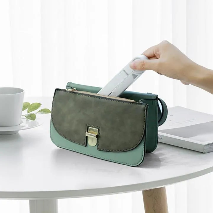 Black foldable tablet holder supporting a tablet in landscape viewing position on a desk