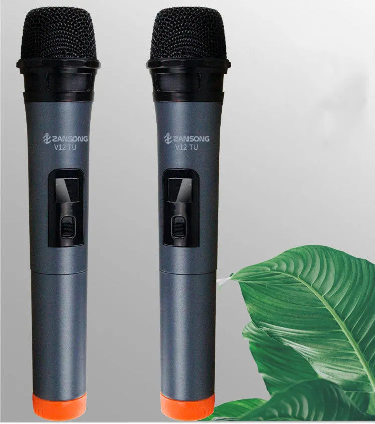 Black dynamic microphone with metal grill, USB receiver, adapter, and audio cable on dark background