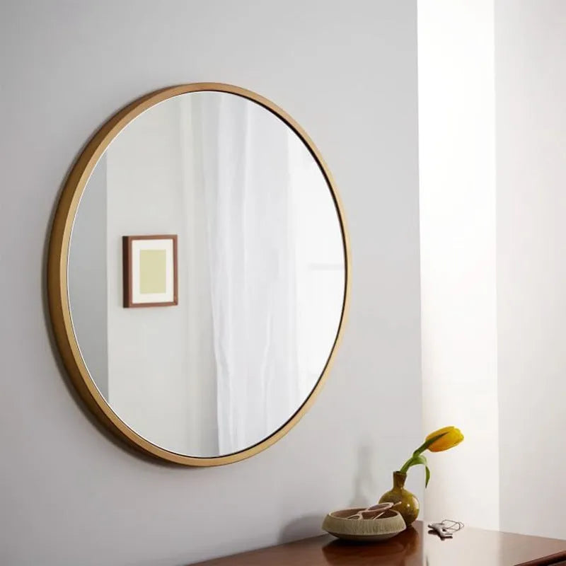 Round metal-framed wall mirror in black, white, or gold, shown in a bathroom setting.