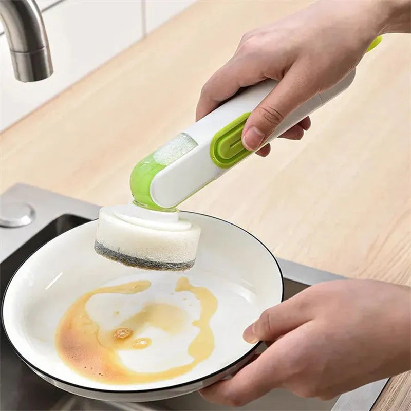 White and red long-handle kitchen cleaning brush with integrated soap dispenser button and two brush heads.