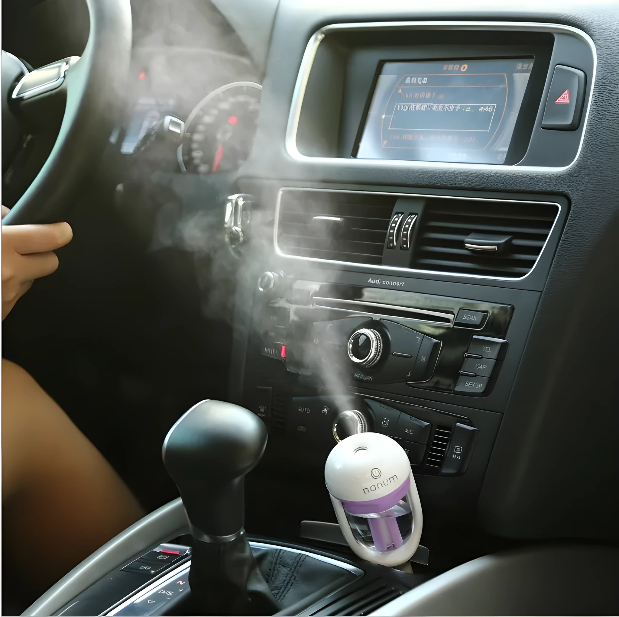 Compact portable car humidifier and air freshener unit with 180-degree rotating mist nozzle.