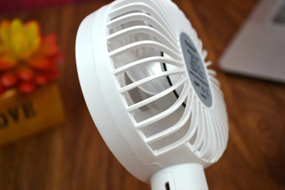 White ORICO FH1 portable USB rechargeable desk fan with three-speed buttons and a fine line pattern on its ABS shell.