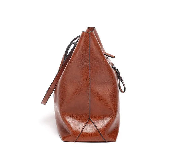 Brown cowhide leather cross body ladies handbag showing two main compartments and internal phone pouch.