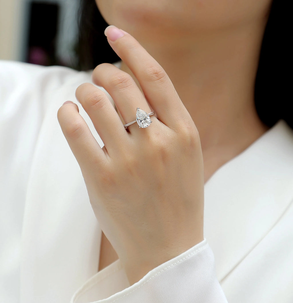 Heart-shaped pear-cut moissanite wedding ring set in S925 silver with platinum plating on white background