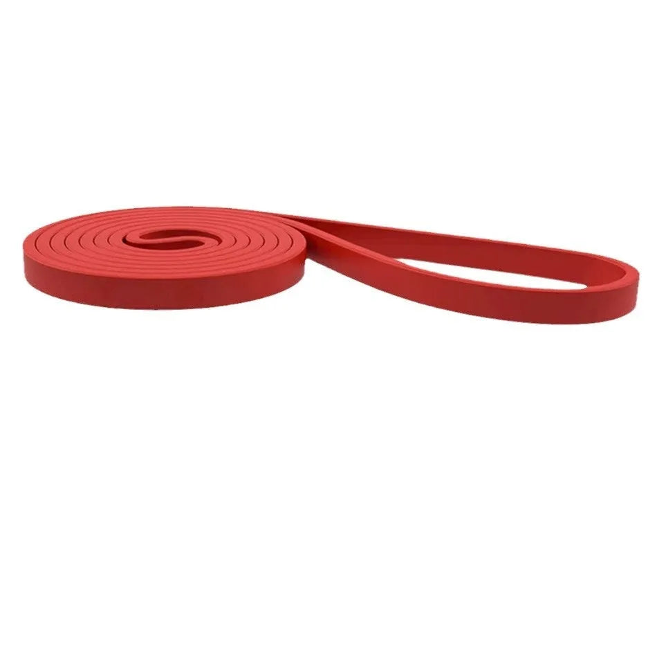 Set of five TPE resistance bands in yellow, red, black, purple, and green on a wooden floor