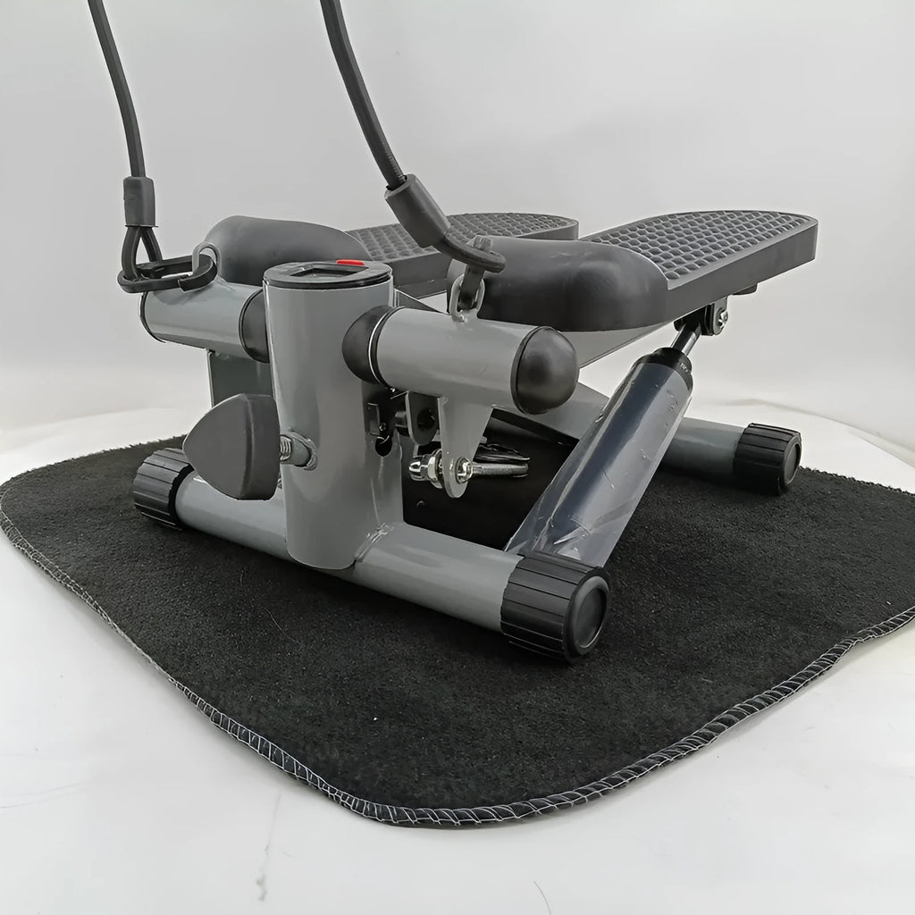 Silver grey hydraulic mini treadmill for waist slimming exercises in a home setting.