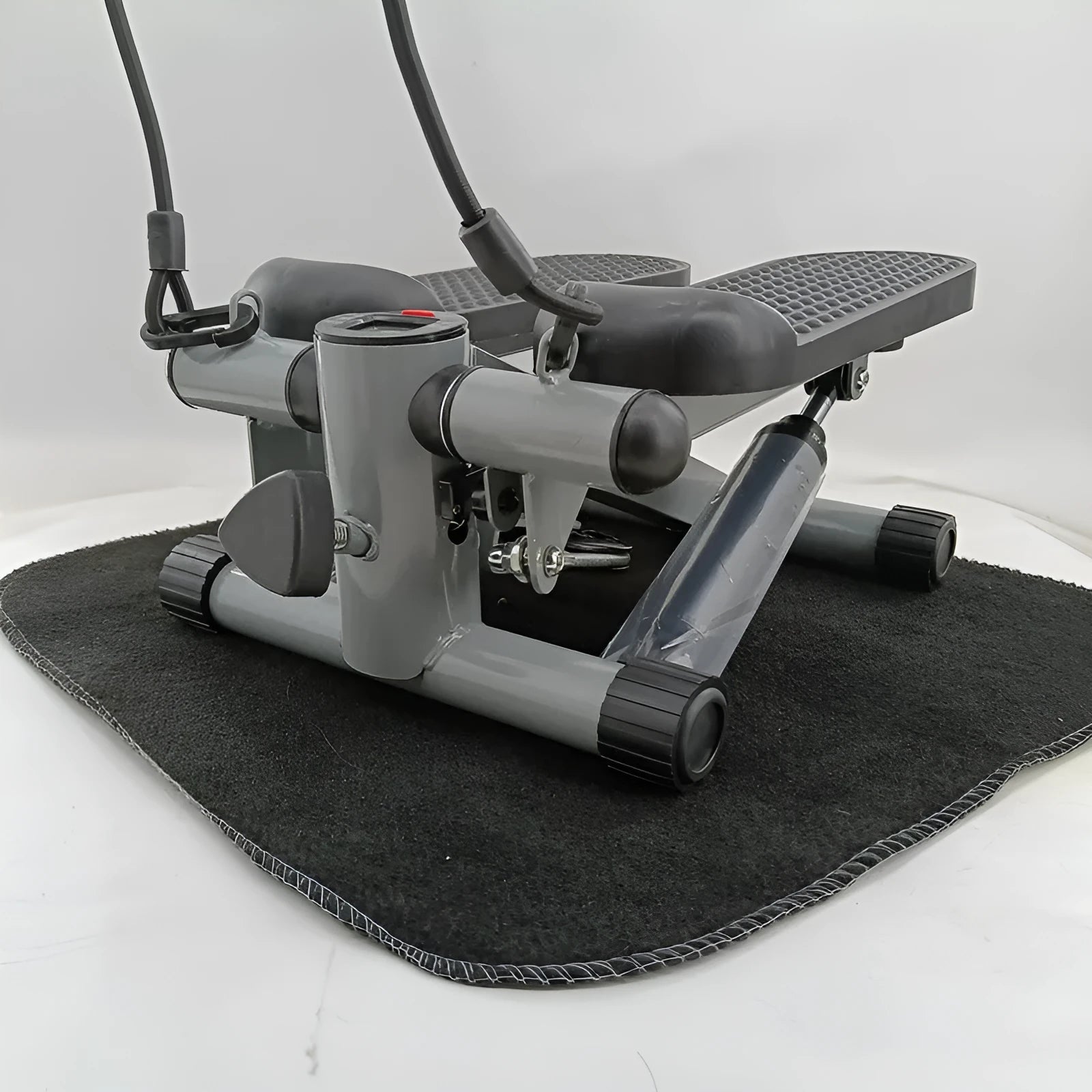 Silver grey hydraulic mini treadmill for waist slimming exercises in a home setting.