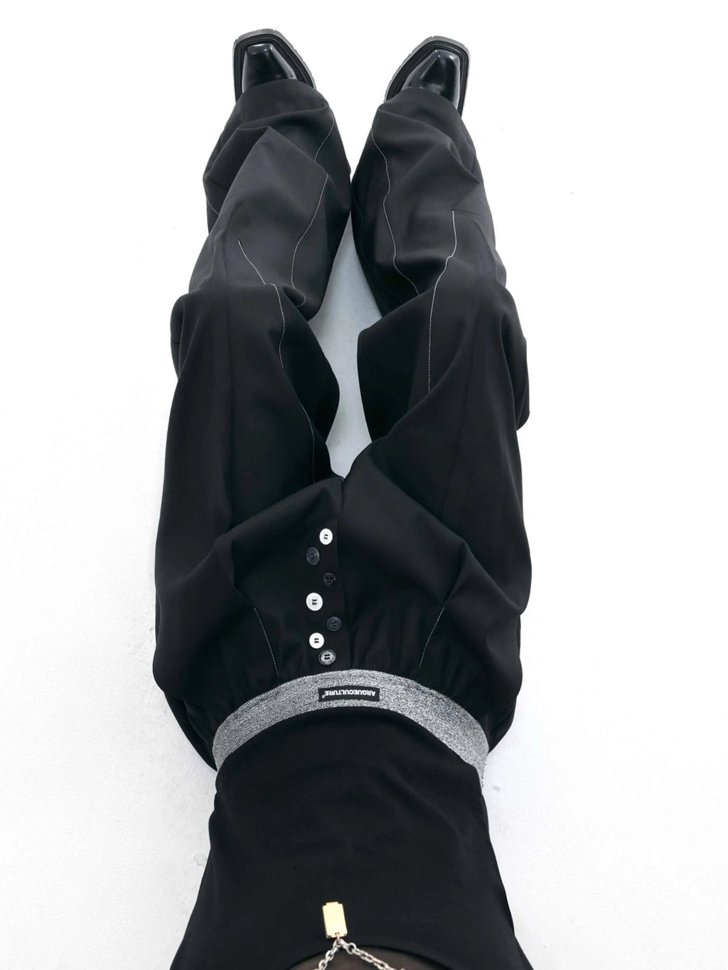 High-waist straight-leg trousers with a button detail on the leg in black or grey.