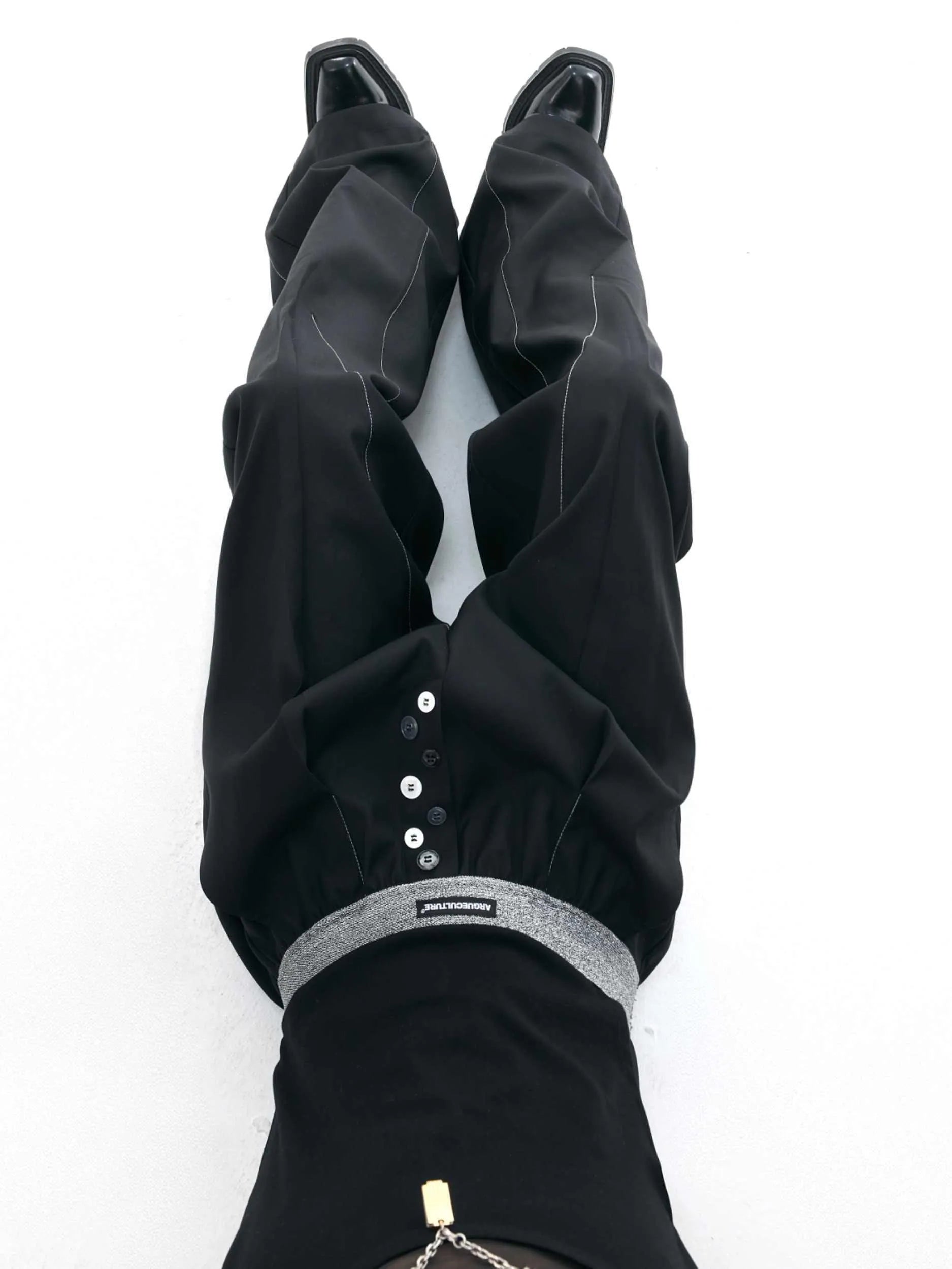 High-waist straight-leg trousers with a button detail on the leg in black or grey.