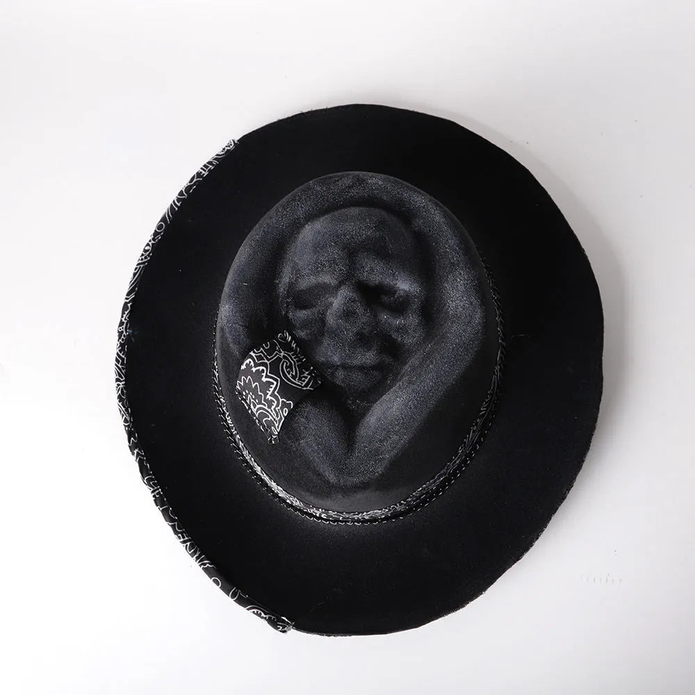 Handmade wool felt hat with conical crown and skull embroidery on a denim base.