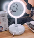 White acrylic LED vanity mirror with double-sided magnification and foldable storage compartments.