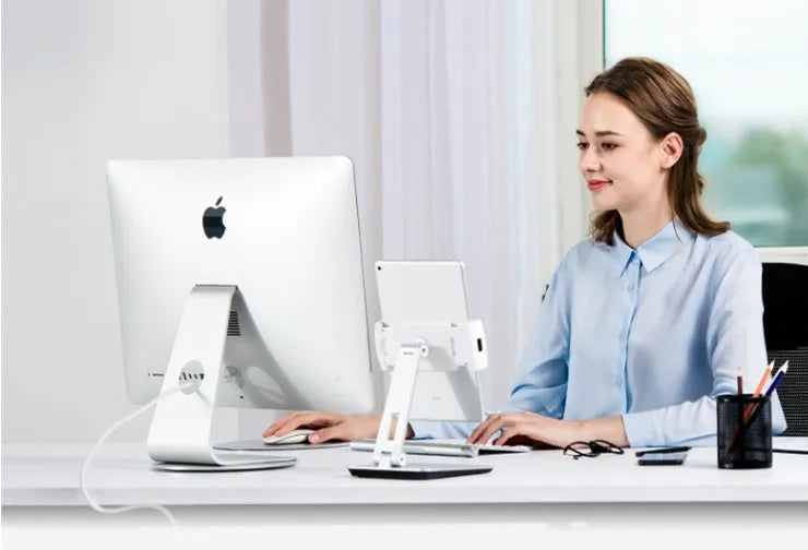 Silver aluminium foldable desktop stand holding a tablet, showing 360-degree rotation.