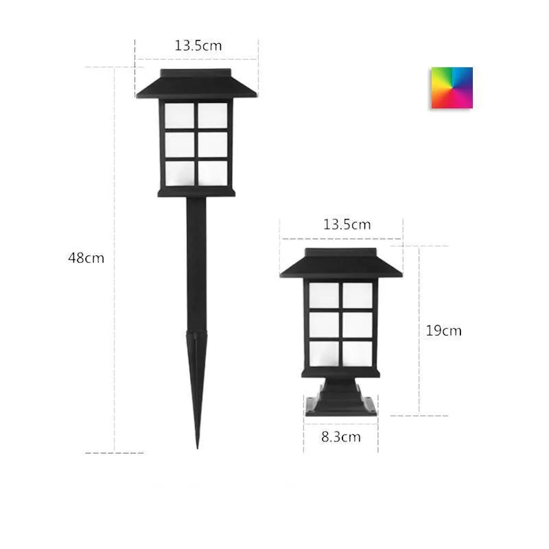 Black solar-powered outdoor LED lawn light with window-style openings, shown in a garden setting.