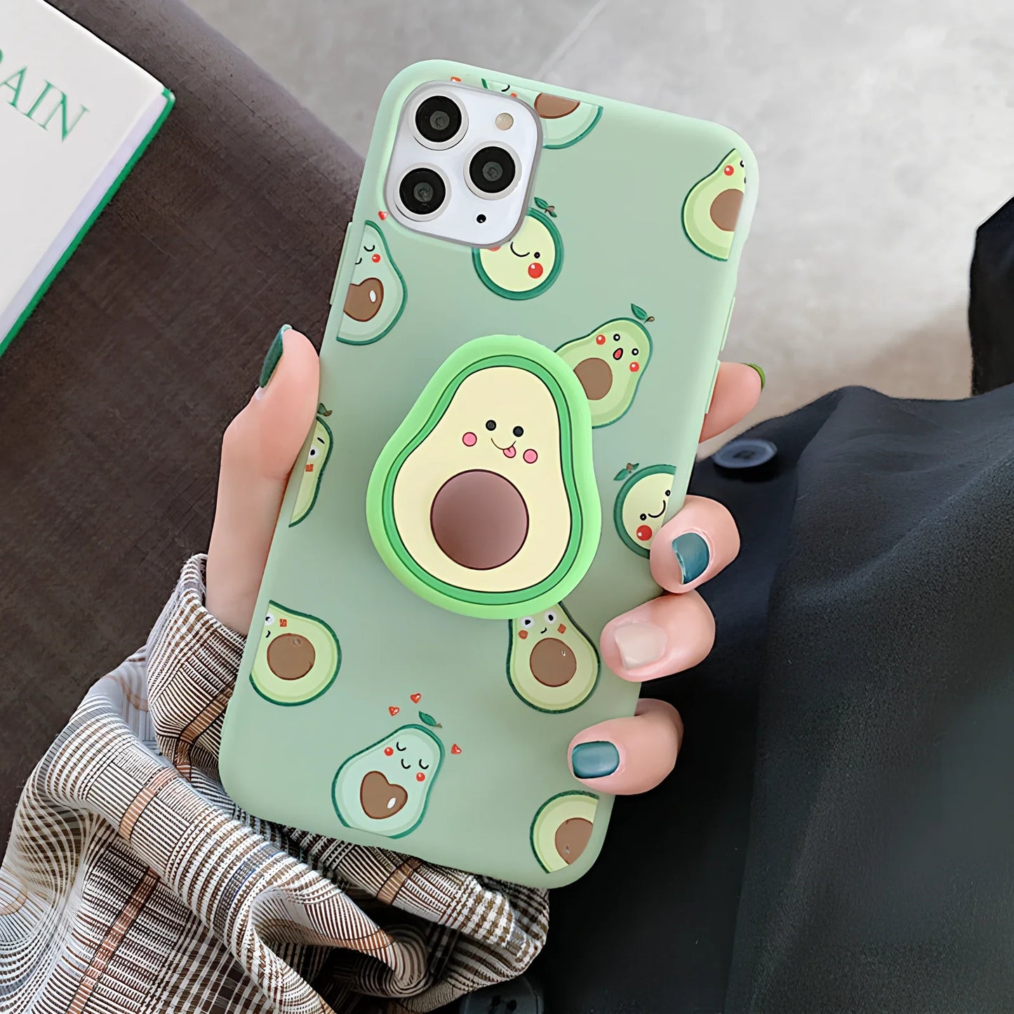 Green avocado pattern silicone iPhone case with metal ring stand attached to back