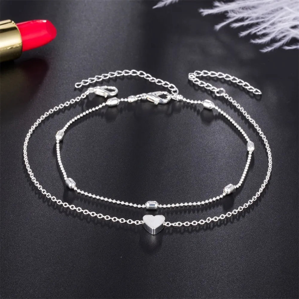 Double-layered retro beach ball chain heart-shaped alloy anklet in gold colour on white background