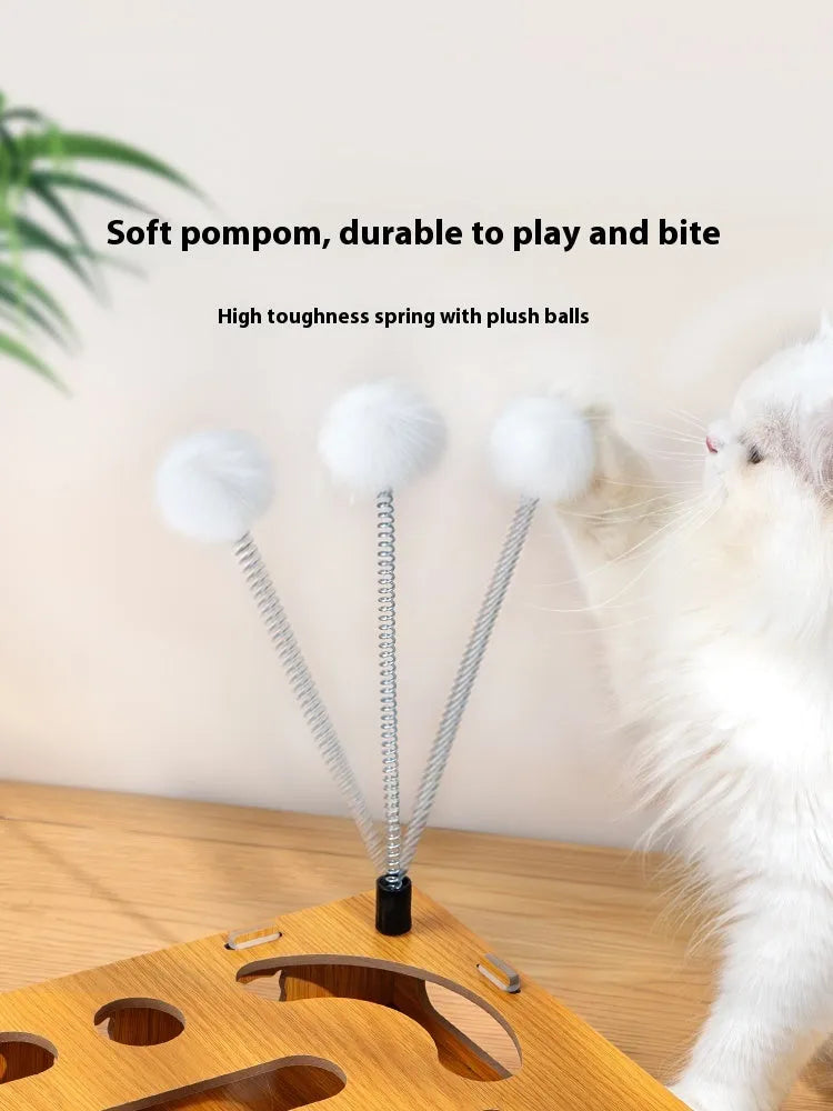 Wooden cat maze box with teasing stick and two bell balls on a floor