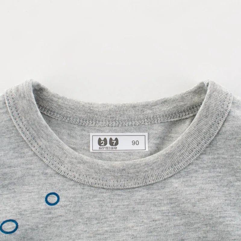 Grey cotton children's T-shirt laid flat, showing plain front and detailed size label.