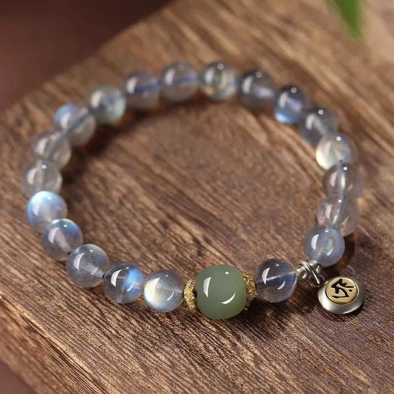 Close-up of an 8mm Moonstone crystal bracelet showing a detailed Thousand-Hand Kwan-yin mouse design.