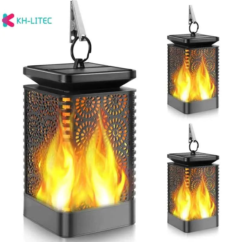 Four black solar-powered hanging lanterns with flickering flame LED light effect for outdoor garden decoration.