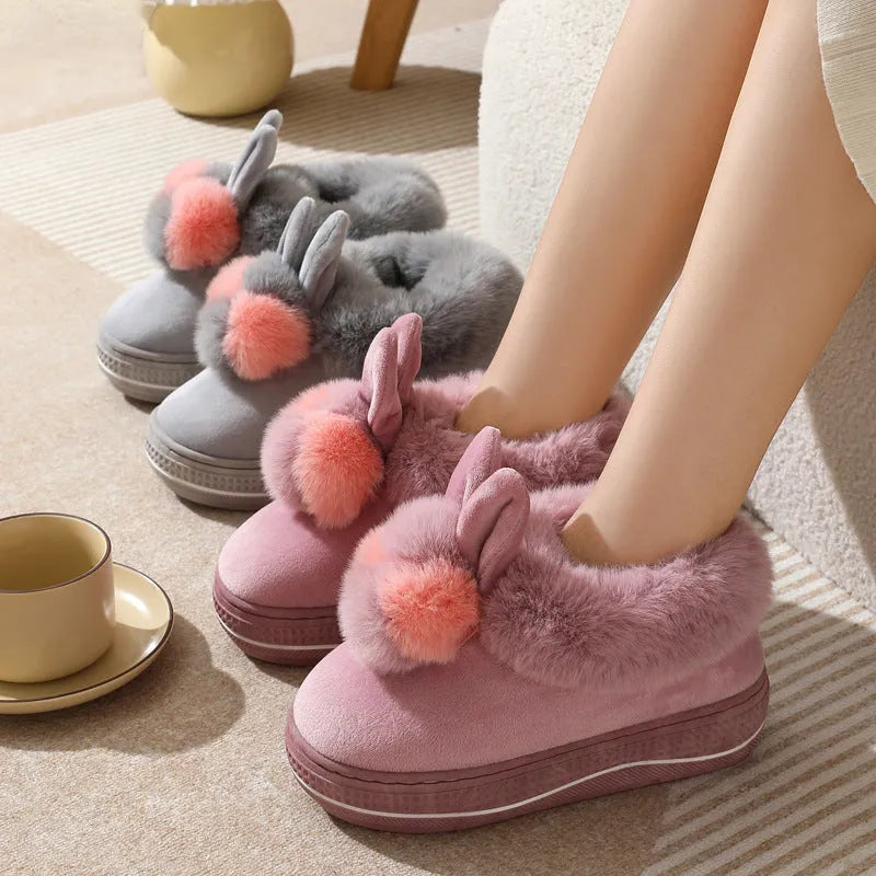 A pair of thick-soled grey plush oversleeve slippers with a textured non-slip sole.