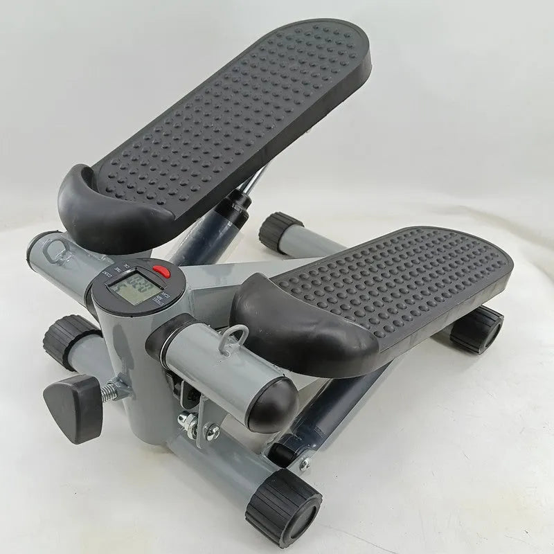 Silver grey hydraulic mini treadmill for waist slimming exercises in a home setting.