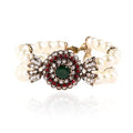 Luxury pearl bracelet in green and red alloy metal on display