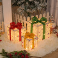 Set of three lighted Christmas gift box decorations with bows and LED lights for outdoor holiday decor