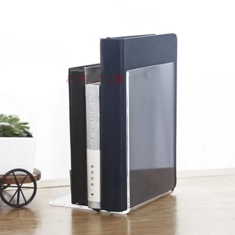 Transparent acrylic bookshelf holding a small stack of books on a wooden desk.