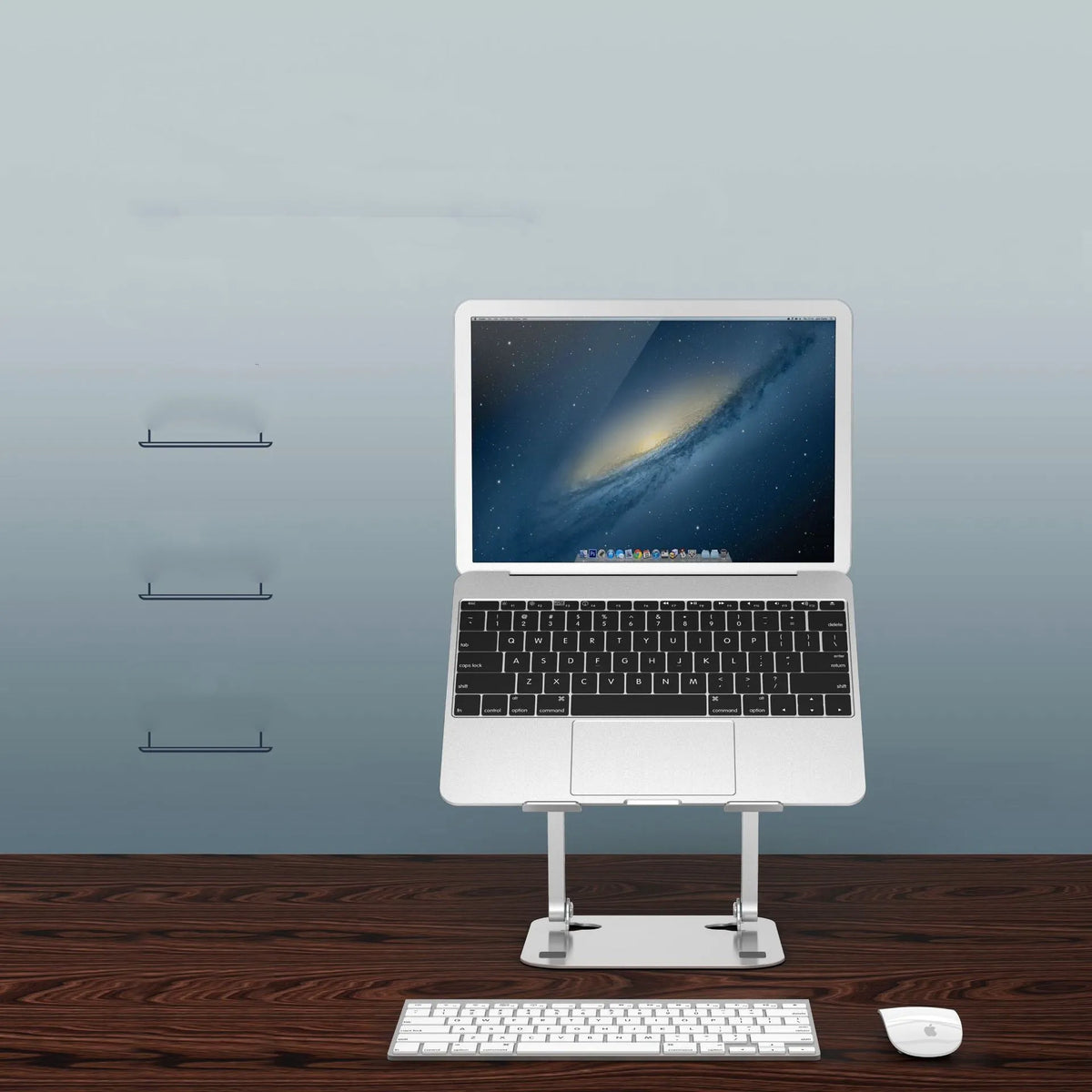 Silver aluminium alloy folding notebook cooling rack with open legs, next to a laptop on a desk