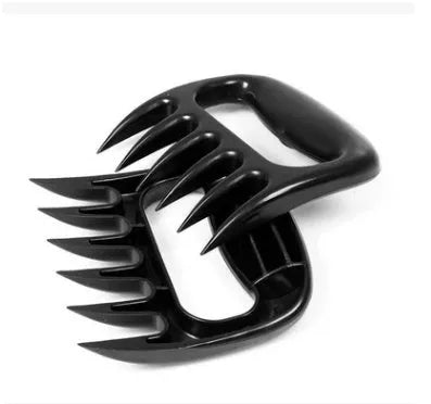 Two black bear claw meat shredding forks for barbecue and kitchen use on a kitchen counter.