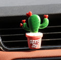 Car air freshener vent clip in plant ornament style, attached to car air conditioning vent
