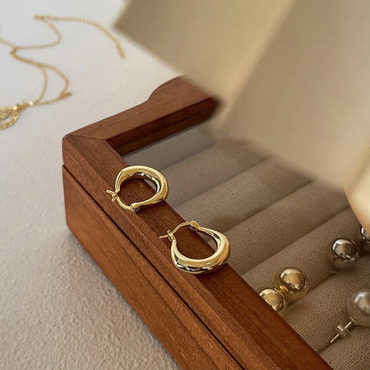 Small fat circle ear clips in white gold and yellow gold finishes for women