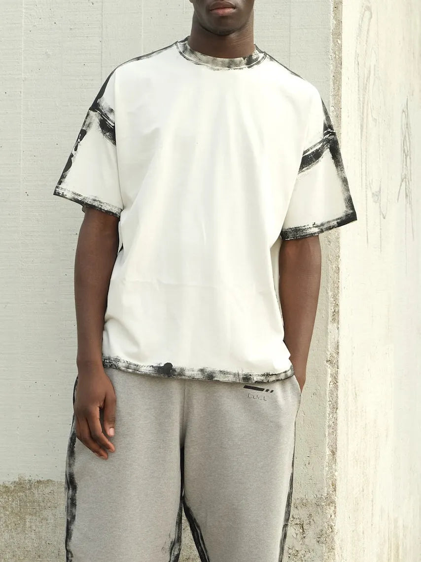 White casual short sleeve top with draped neckline and printed design detail.