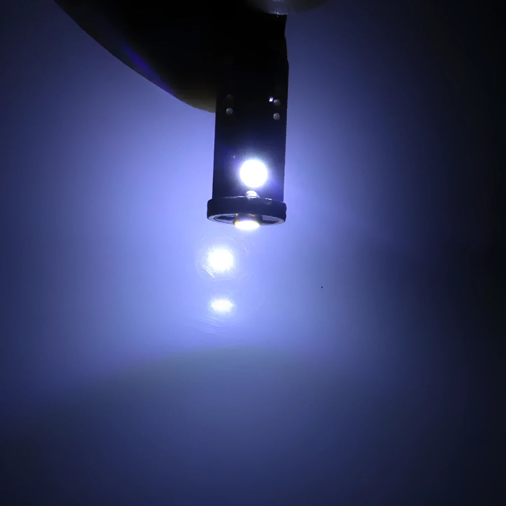 Single T10 W5W LED car interior light bulb with bright white LEDs on a dark board.