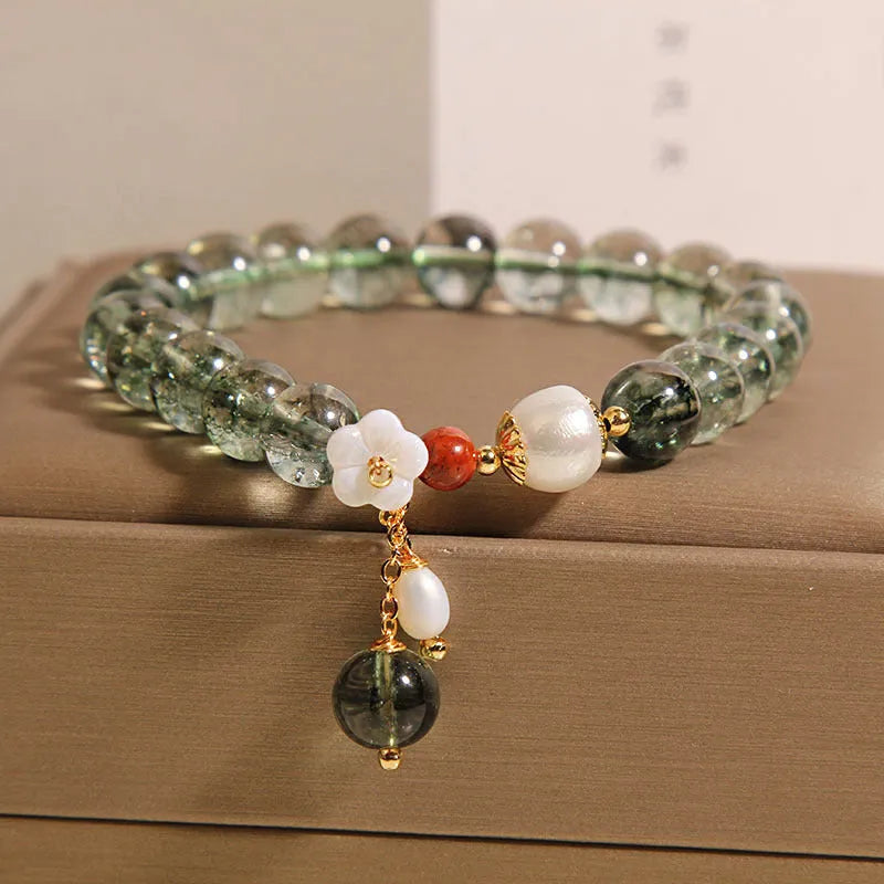 Green phantom quartz crystal bracelet for women with a small white shell flower accent.