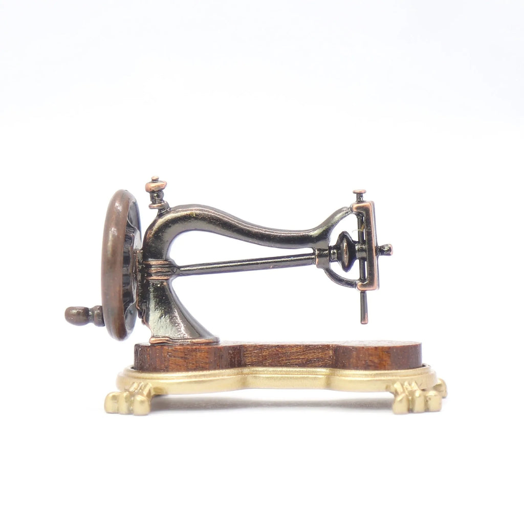 Brown metal simulation mini hand sewing machine dollhouse accessory on display