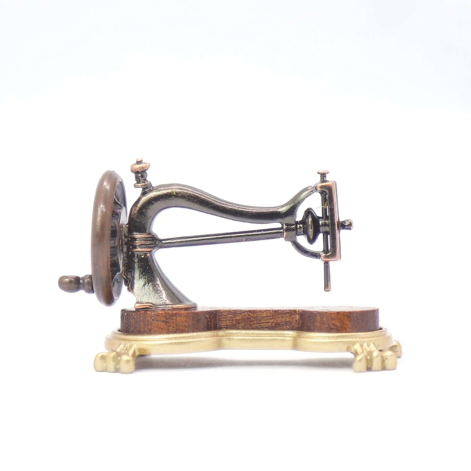 Brown metal simulation mini hand sewing machine dollhouse accessory on display