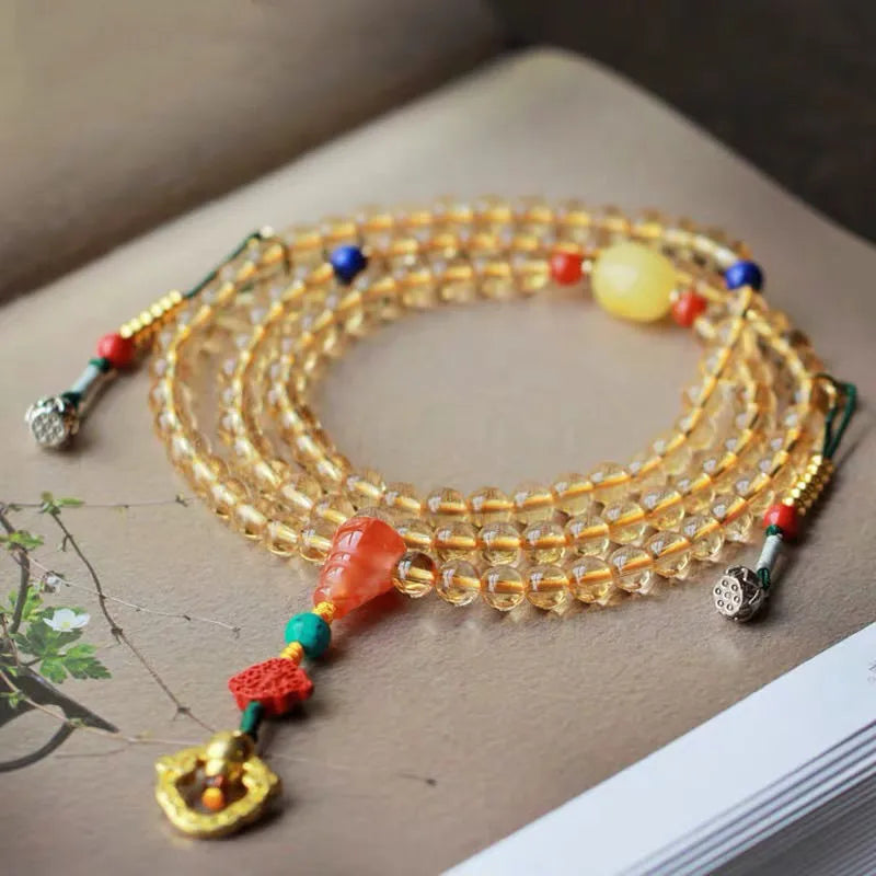 Yellow natural Brazilian citrine bracelet with 1mm beads and filament details on a wrist.