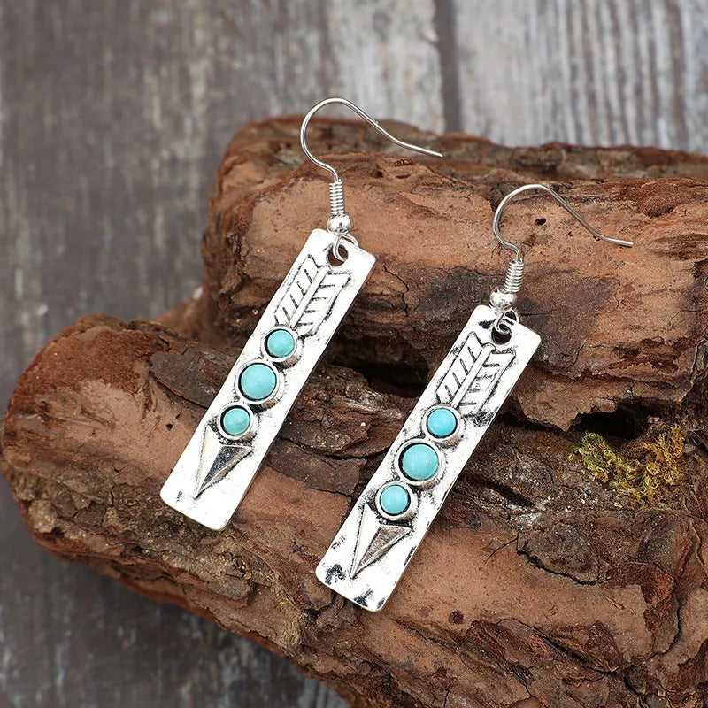 Long silver geometric drop earrings with inlaid turquoise details on a retro-style zinc alloy setting.
