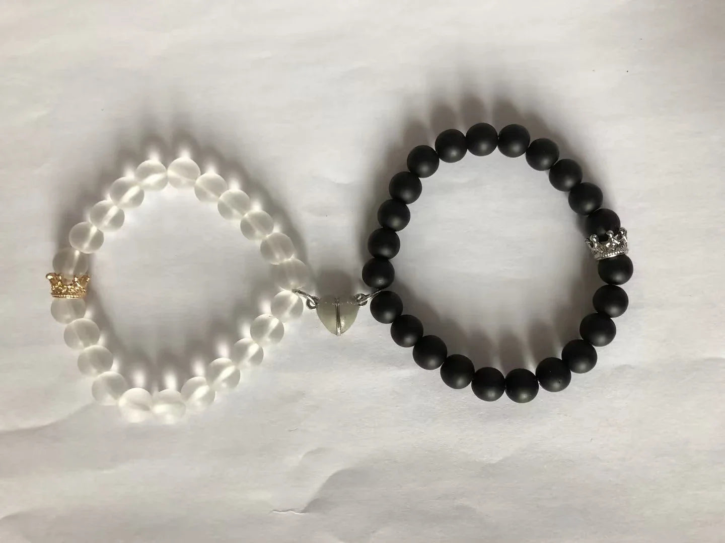 Luminous glow-in-the-dark crown bracelet set in white and black colors, showcasing a unique design and enchanting nighttime glow