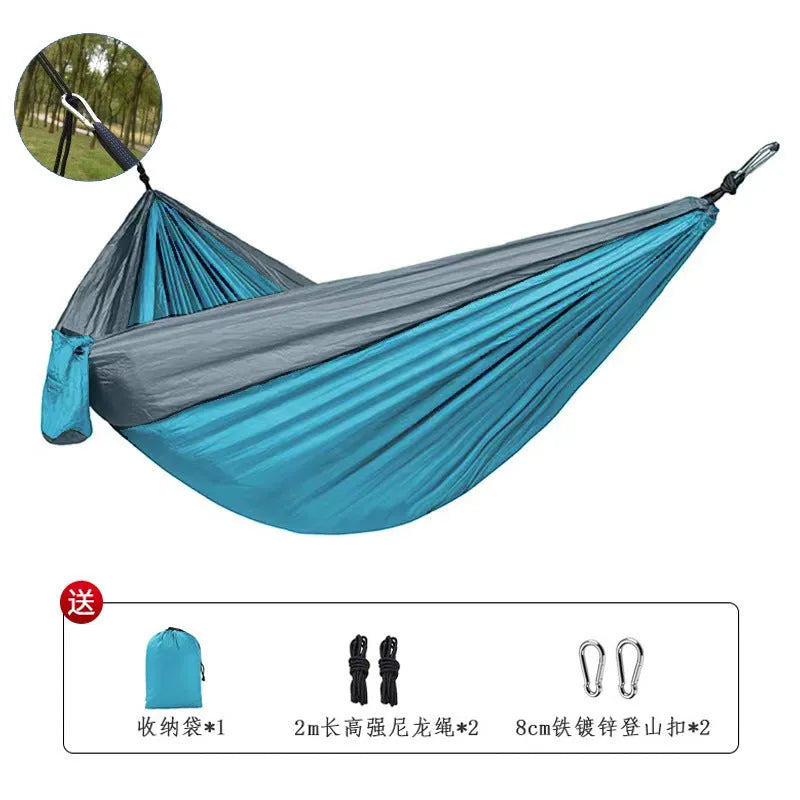 Blue nylon parachute cloth outdoor camping hammock hung between trees