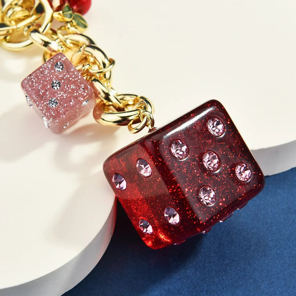 Square metal keychain pendant with a vintage two-tone cherry dice pattern.