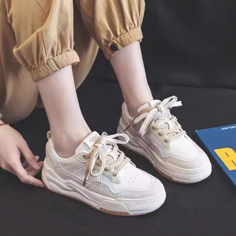 Pink and white low top women's sneakers with a rubber sole and height increasing feature.