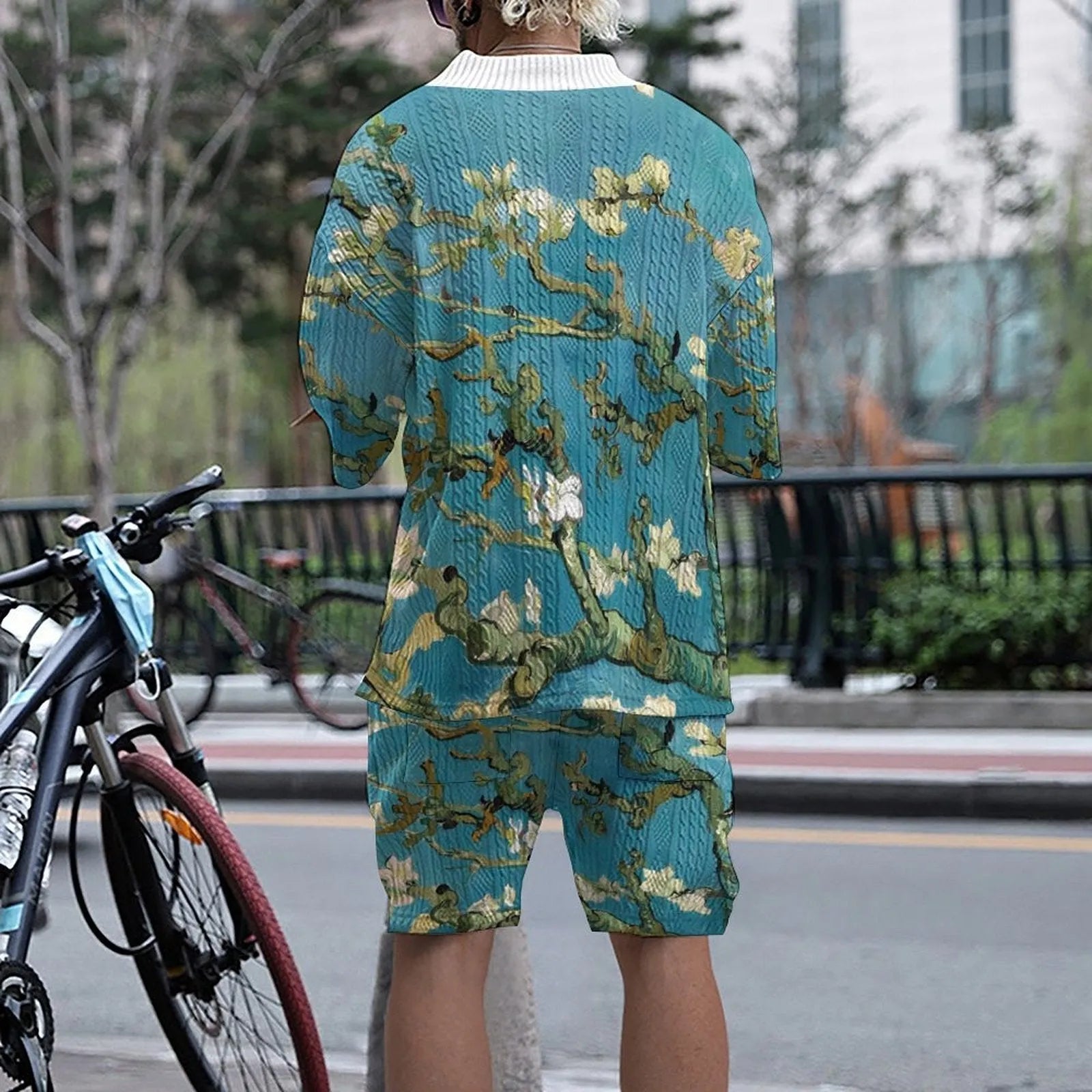 Man wearing a peacock blue 3D printed knit shorts suit with a T-shirt jacket.