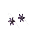 A pair of retro-style purple flower-shaped alloy earrings for women on a plain background.