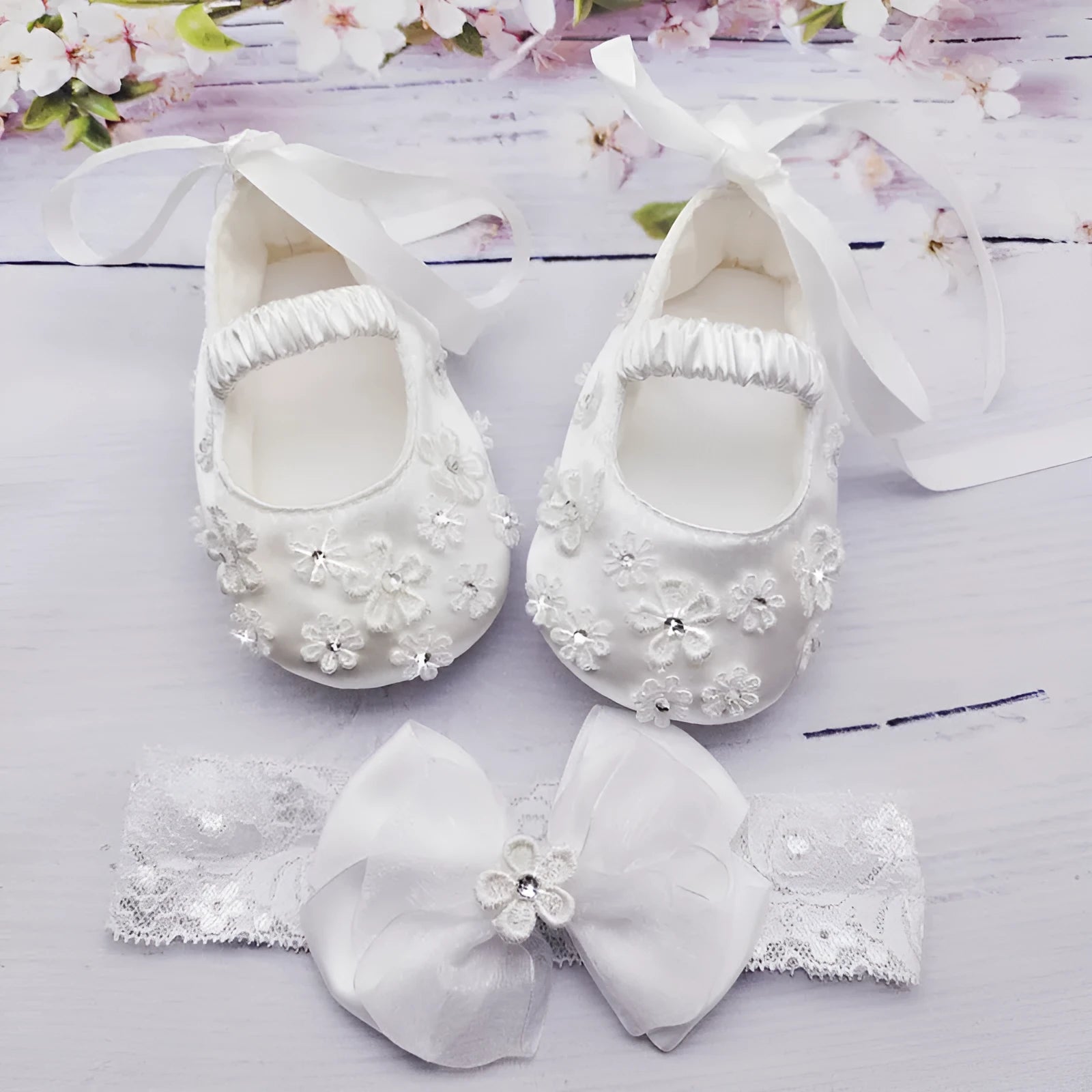 White baby soft bottom cloth princess shoes with rhinestone detail on a white background