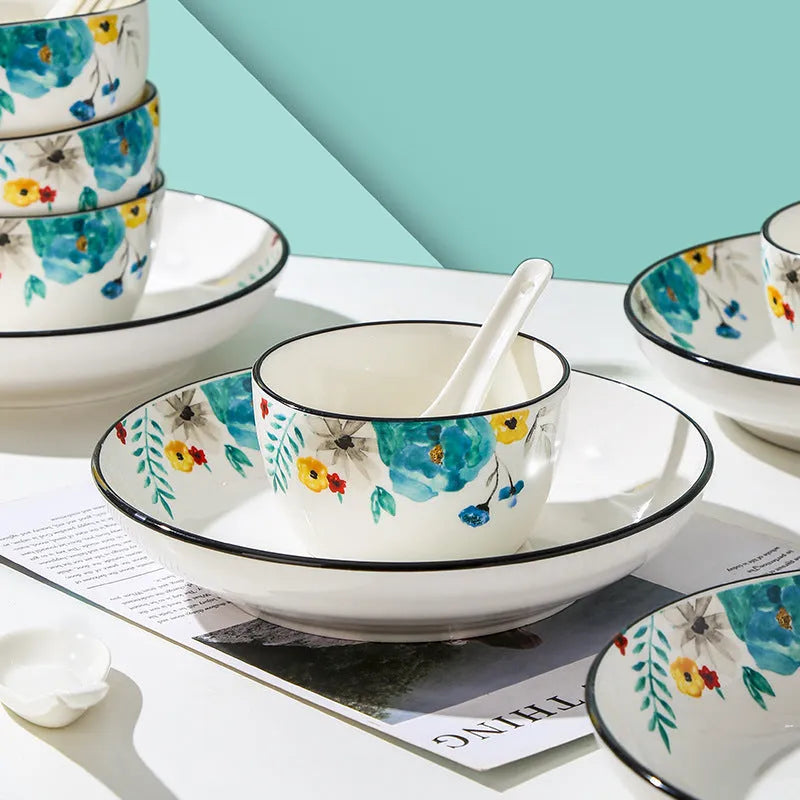 Flower In Ink 22-piece bone china tableware set with floral pattern, bowls, plates, and spoons on a table.