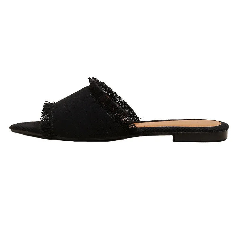 Women's flat denim slippers with a tassel decoration in apricot colour.